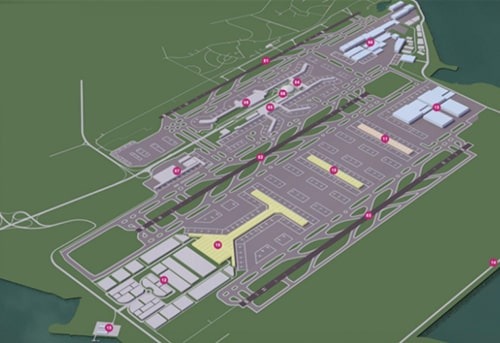 Aerial view of a large commercial airport with multiple terminals, runways, and parking lots.