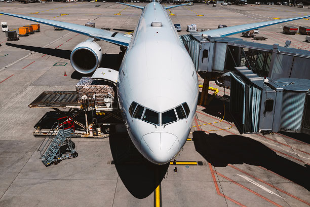 Sleek commercial airliner with loading equipment on tarmac.