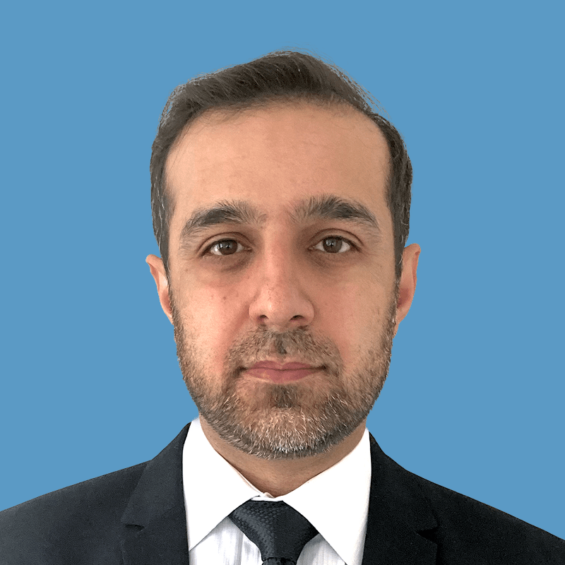 Portrait of a middle-aged man with dark hair, beard, and wearing a suit and tie.