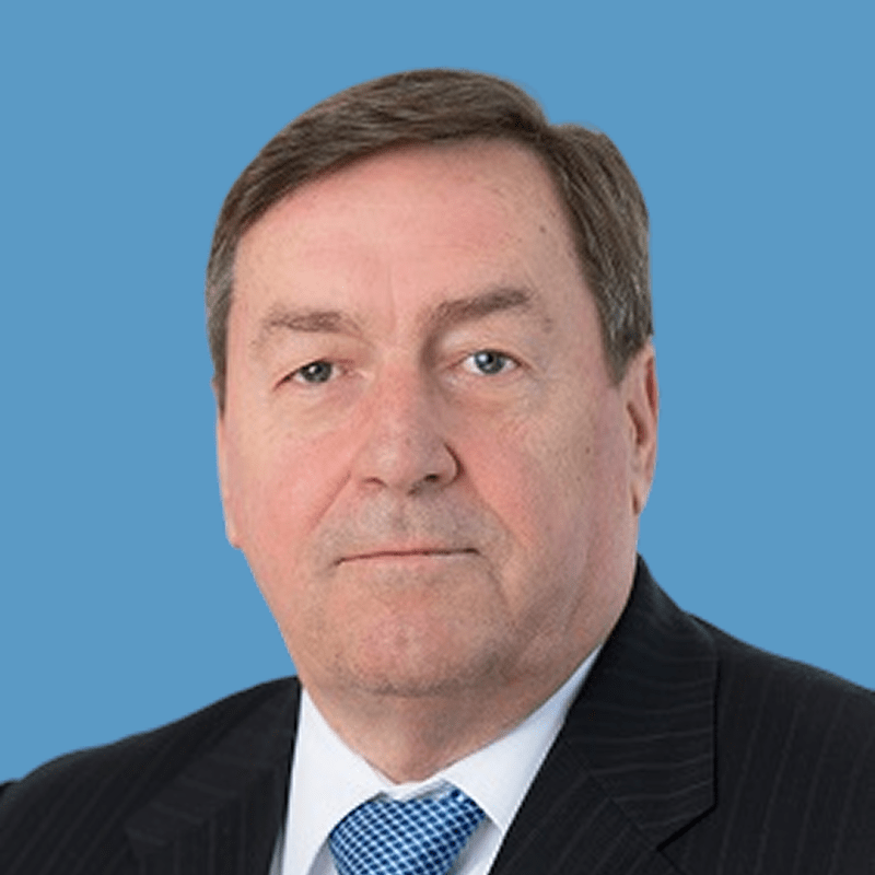 Portrait of a middle-aged man with short brown hair, wearing a dark suit and blue and white checkered tie.