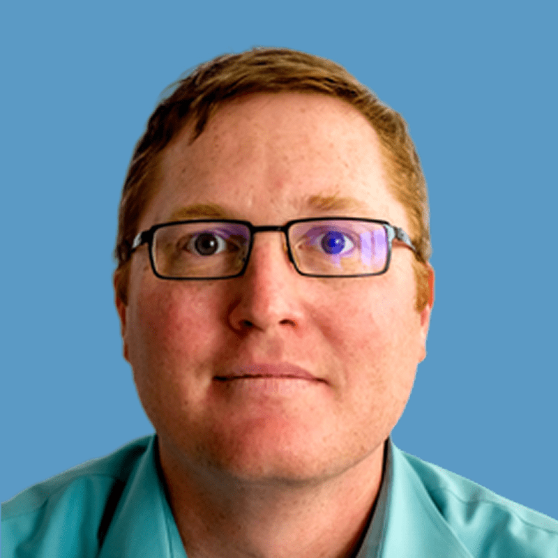 Person wearing glasses and a green shirt against a blue background.